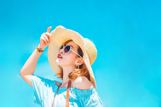 summer holidays, vacation, travel and people concept - smiling young woman in sun hat on beach over sea and blue sky background.?jump on the beach.copy space