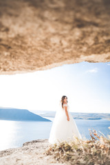 Fototapeta na wymiar Beautiful young bride posing on the background sea