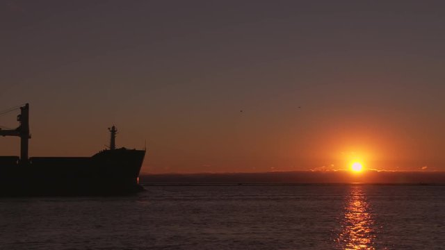 Freighter Departing at Sunset, Fraser River 4K UHD. A freighter heading out into Georgia Strait at sunset. British Columbia, Canada, near Vancouver. 4K. UHD.
