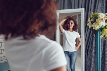 Curly haired girl with freckles in blank white t-shirt. Mock up.