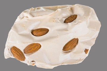 Turkish honey nougat with almonds. Piece of yummy sweet candy isolated on gray background.