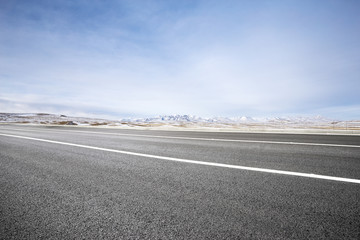 Fototapeta premium empty asphalt road with beautiful snow mountains