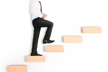 business person stepping up  toy staircase