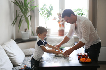  boy and dad roll out dough in cozy real interior