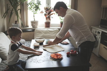 son and father cooking together, cozy real kitchen