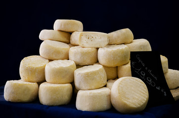 market stall in Italy with traditional hard cheese made of milk of cow and goat (mucca e capra)