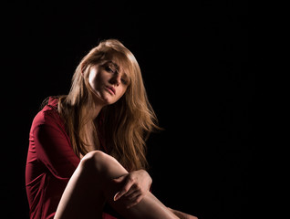 portrait of woman fashion model low key on black background blond hair long legs and eyes