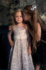 Two girls, sisters. girlfriend, model in a beautiful studio with flowers. Portrait, childhood, fashion.