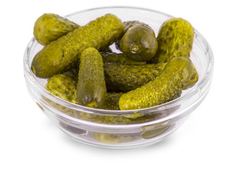 some pickled cucumbers in a glass bowl on a white background.