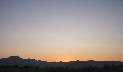 Obraz premium Atardecer detrás de la montaña