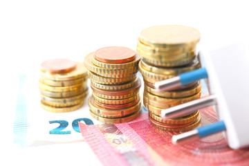 Electric plug with money and coins. Energy saving concept. Soft and selective focus.