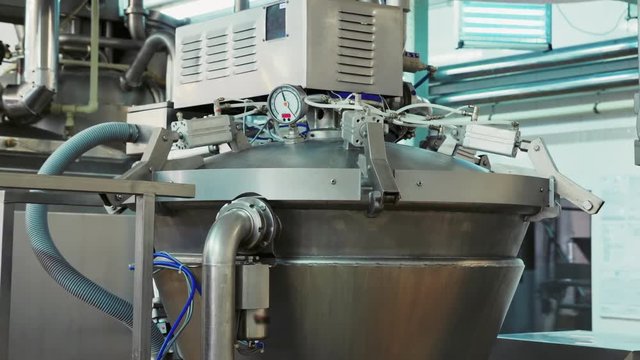 The process of heating milk in a pasteurization tank. Dairy factory. Line production of dairy products