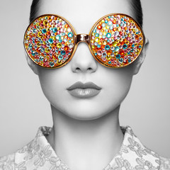 Portrait of beautiful young woman with colored glasses. Beauty fashion. Perfect make-up. Colorful...