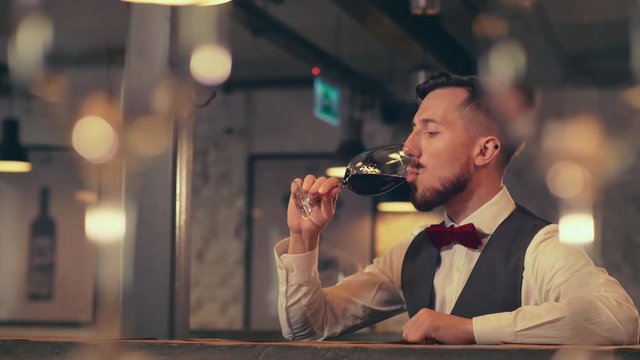Young man drinking wine in a restaurant