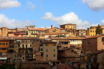 Fototapeta na wymiar Beautiful landscape the roofs of houses of Europe Sienna old town in Italy under blue sky with clouds