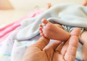 Baby's foot With the hands of older adults