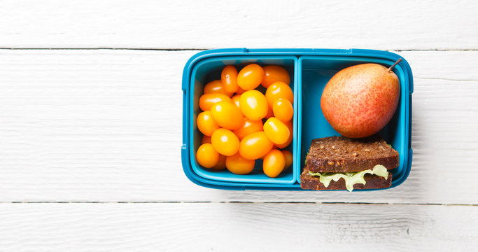 Image of cherry tomato, pear, sandwich in lunchbox