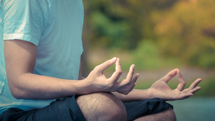 The acting setup of Yoga concept. A asian young man doing Yoga outdoor by the lake.