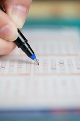 Picture of human's hand with lottery ticket