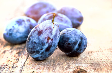 Fresh ripe plums on a wooden background