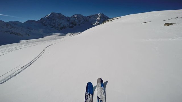 Mountaineer backcountry skiing along a snowy ridge. In background blue cloudy sky and shiny sun and Tre Cime, Drei Zinnen in South Tirol, Dolomites, Italy.  Adventure winter extreme sport.