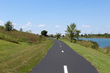 The walkway in the park near the lake on a sunny day.