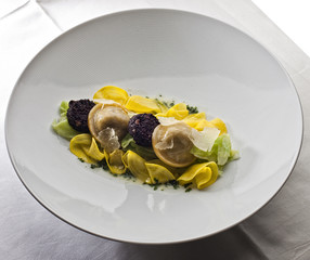 Gericht mit Ravioli auf weißem Teller