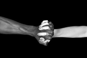 A hands of black man and white woman on black background