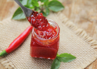 Sweet bell pepper and chili pepper sauce, confiture, jam in a glass jar. 
