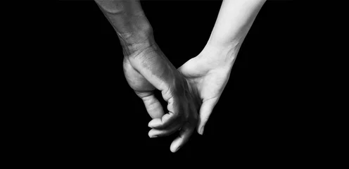 Hände eines schwarzen Mannes und einer weißen Frau auf schwarzem Hintergrund © Curto