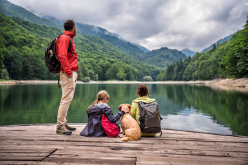 Family with dog resting on a pier