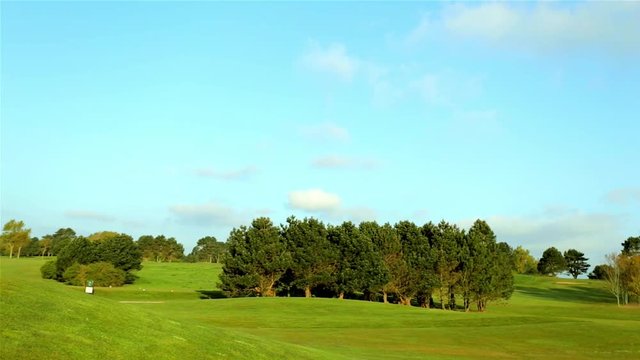 General view of a green golf course on a bright sunny day. Idyllic summer landscape. Sport, relax, recreation and leisure concept.