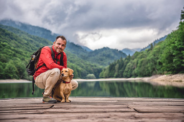 Hiker with a dog on a pier posing