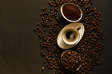 Espresso, beans and ground coffee on brown wooden background. Top view. Space for copy