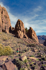 Trail running girl in mountains on rocky path