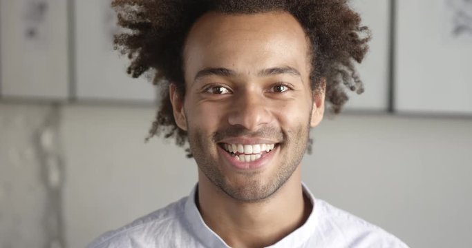 Portrait of smiling african designer happy to provide services for online marketplaces. Close up. Slow motion.