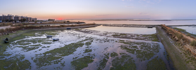 Sunrise aerial seascape view of Olhao salt marsh Inlet, waterfront to Ria Formosa natural park. Algarve.
