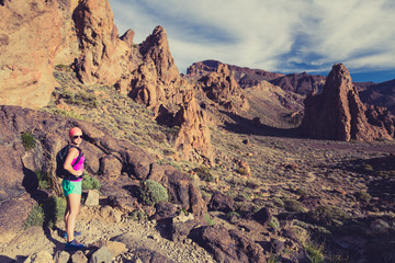 Happy girl hiker walking on mountain path, backpacker adventure