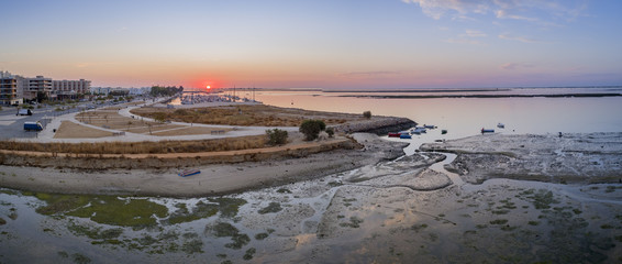 Sunrise aerial seascape view of Olhao salt marsh Inlet, waterfront to Ria Formosa natural park. Algarve.