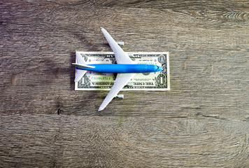The airplane lies on a strip of one dollar. Landing strip for airplanes of dollar
