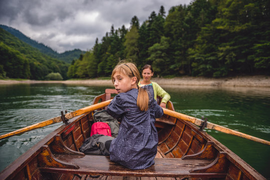 Mother and daughter rowing a boat on the lake