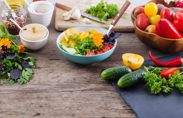  vegetarian salad with flowers on wooden table