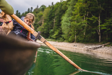 Mother and daughter with a dog rowing a boat