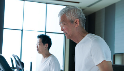 Obraz premium Happy Asian senior couple running on treadmill healthy lifestyle