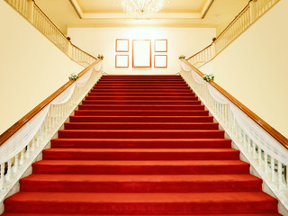 empty red carpet with white luxury stairs with spotlight and blank white frame on top. symmetry background wallpaper