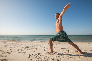 Fototapeta na wymiar Adult concentrated man performs asana of yoga