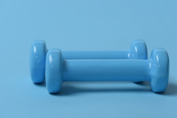 Health regime and fitness symbols. Dumbbells made of blue plastic