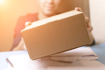 The man gives a parcel to the post office. Mail.