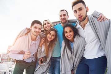 Fototapeta premium Portrait of a young and happy people at rest on the pier. Friends enjoying a game on the lake. Positive emotions.