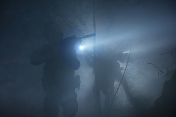 Special Forces soldiers in action. Elite squad moves through fog and smoke.
